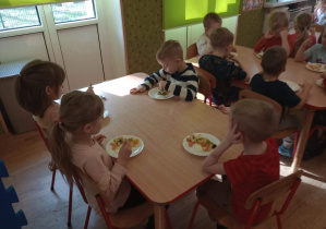 Dzieci jedzą sałatkę owocową